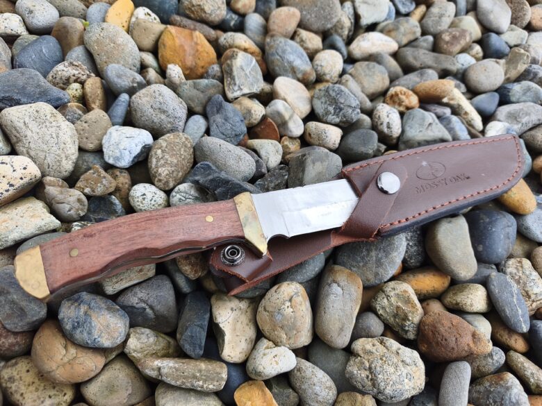 キャンプ用のシースナイフを地面に置いているところ