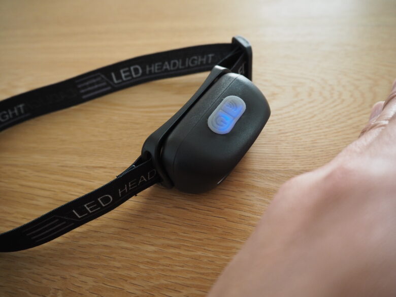 ダイソーの充電式LEDヘッドライトに手をかざして光が消えているところ