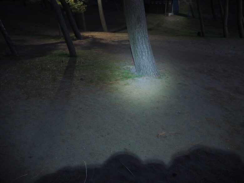 ダイソーの充電式LEDヘッドライトで遠くを照らしているところ